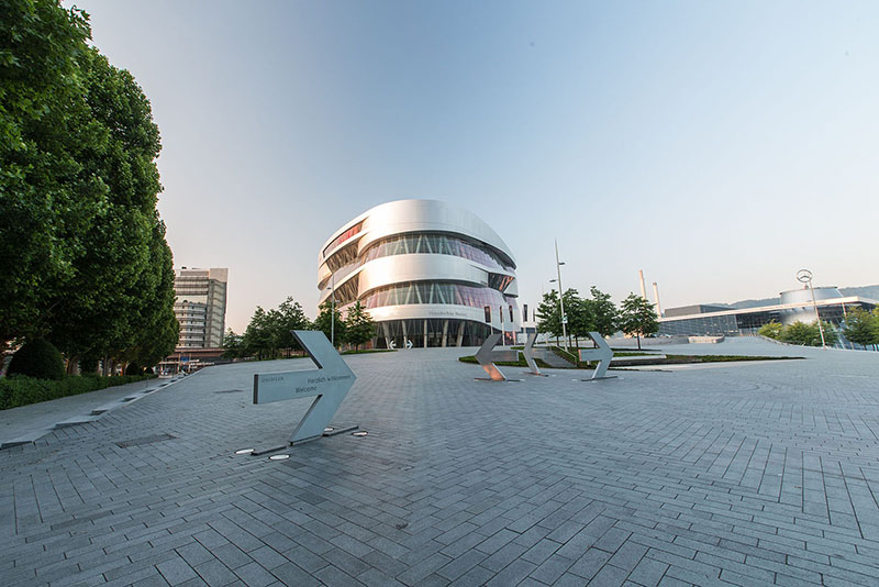 Hill in front of Mercedes-Benz Museum at dusk with museum in the background.